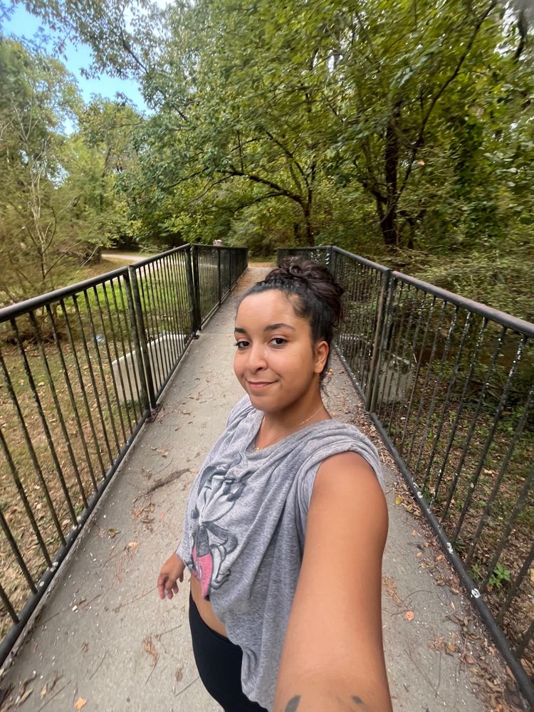 Hallie on a footbridge on a wooded trail